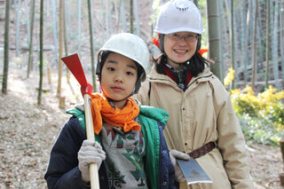 鶴嘴（ツルハシ）を持つ小学4年生と唐鍬（トウグワ）を持つお母さん。なかなか触れる機会のない道具の使い方も覚えられます。