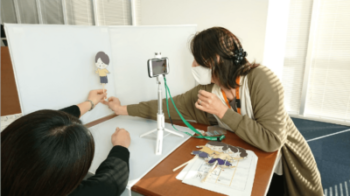 白背景の前にパペット（人形）を配置して撮っているところです。