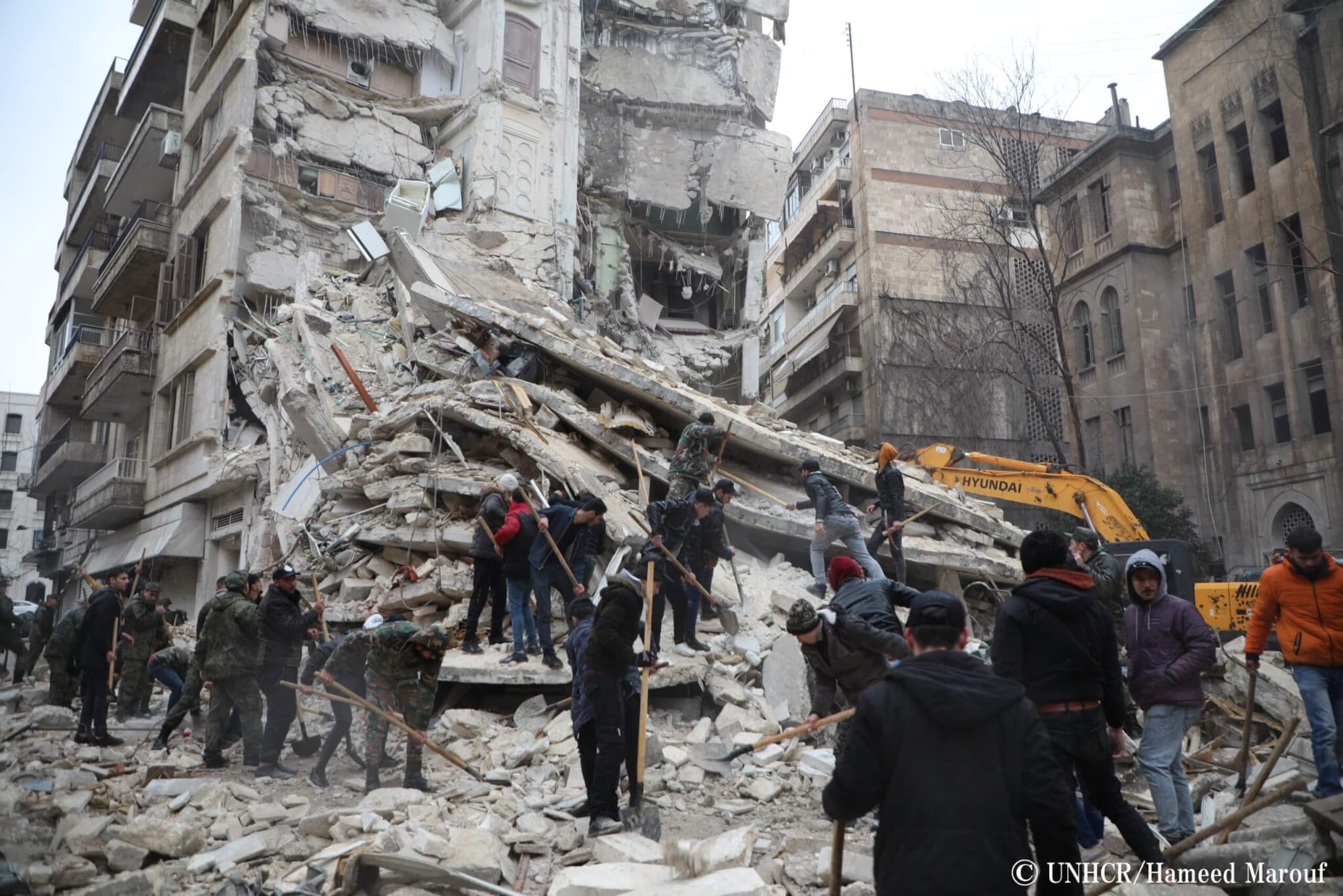 シリア・アレッポにて、倒壊した建物の瓦礫のなかから生存者を探す人々
