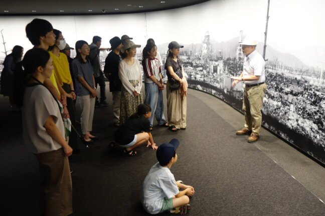 「原爆資料館」で被爆後の広島市街地のパノラマ写真の前で、多賀さんから説明を受けました