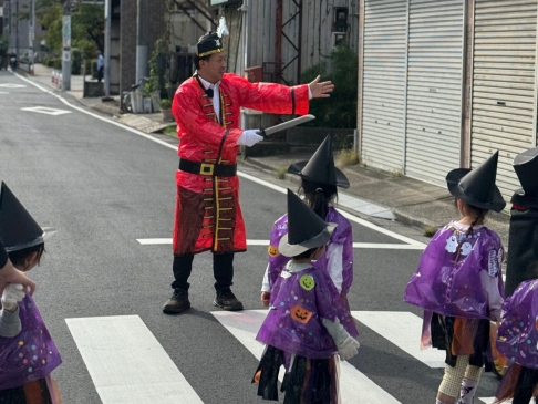 仮装した園長先生に守られて、横断歩道を渡ります。※手に持っているのはおもちゃの剣です。