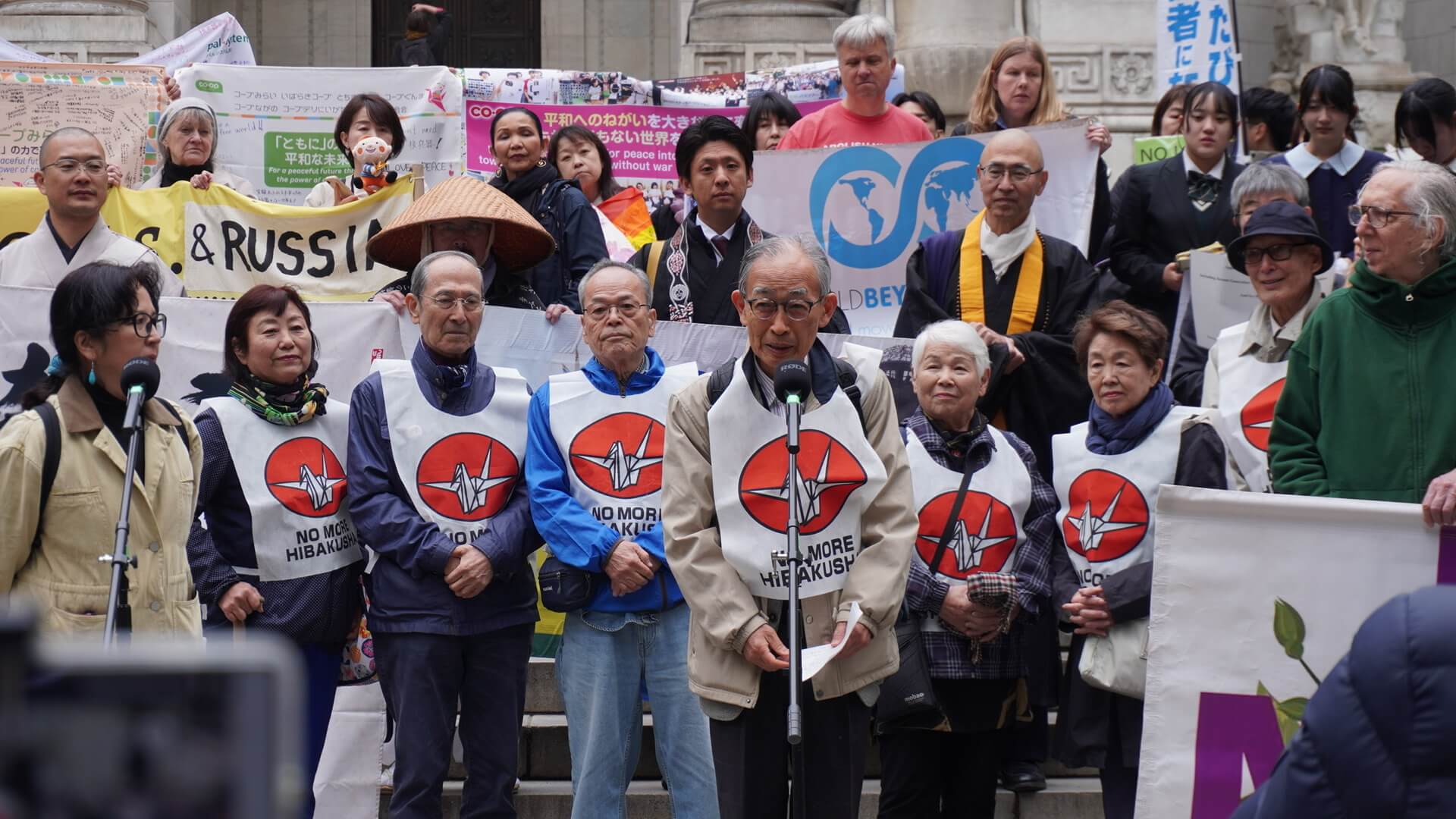 出発前の集会でスピーチをする、浜住治郎事務局長（日本被団協）