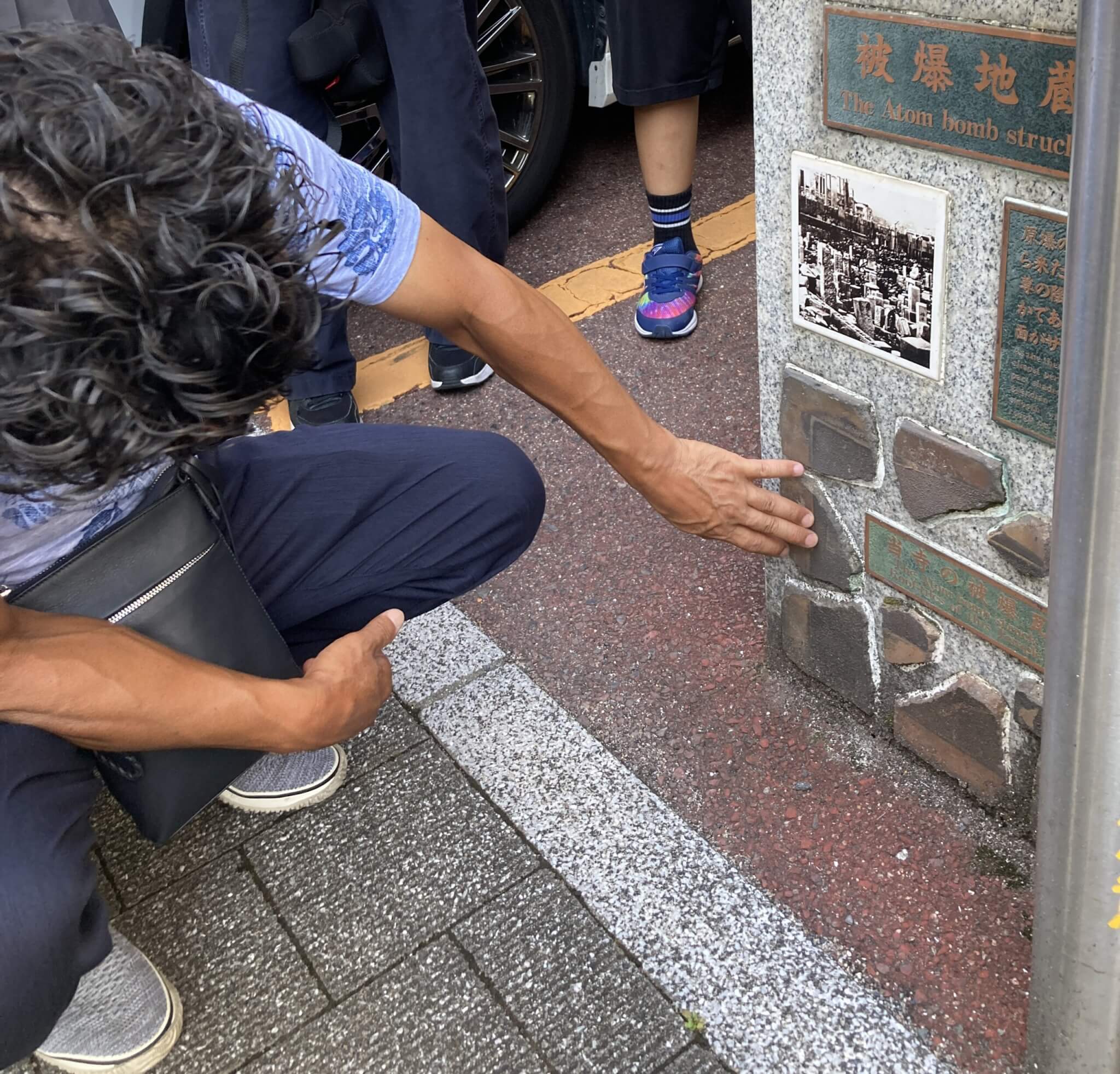 被爆樹木の前で、多賀さんの説明に耳を傾ける参加者
